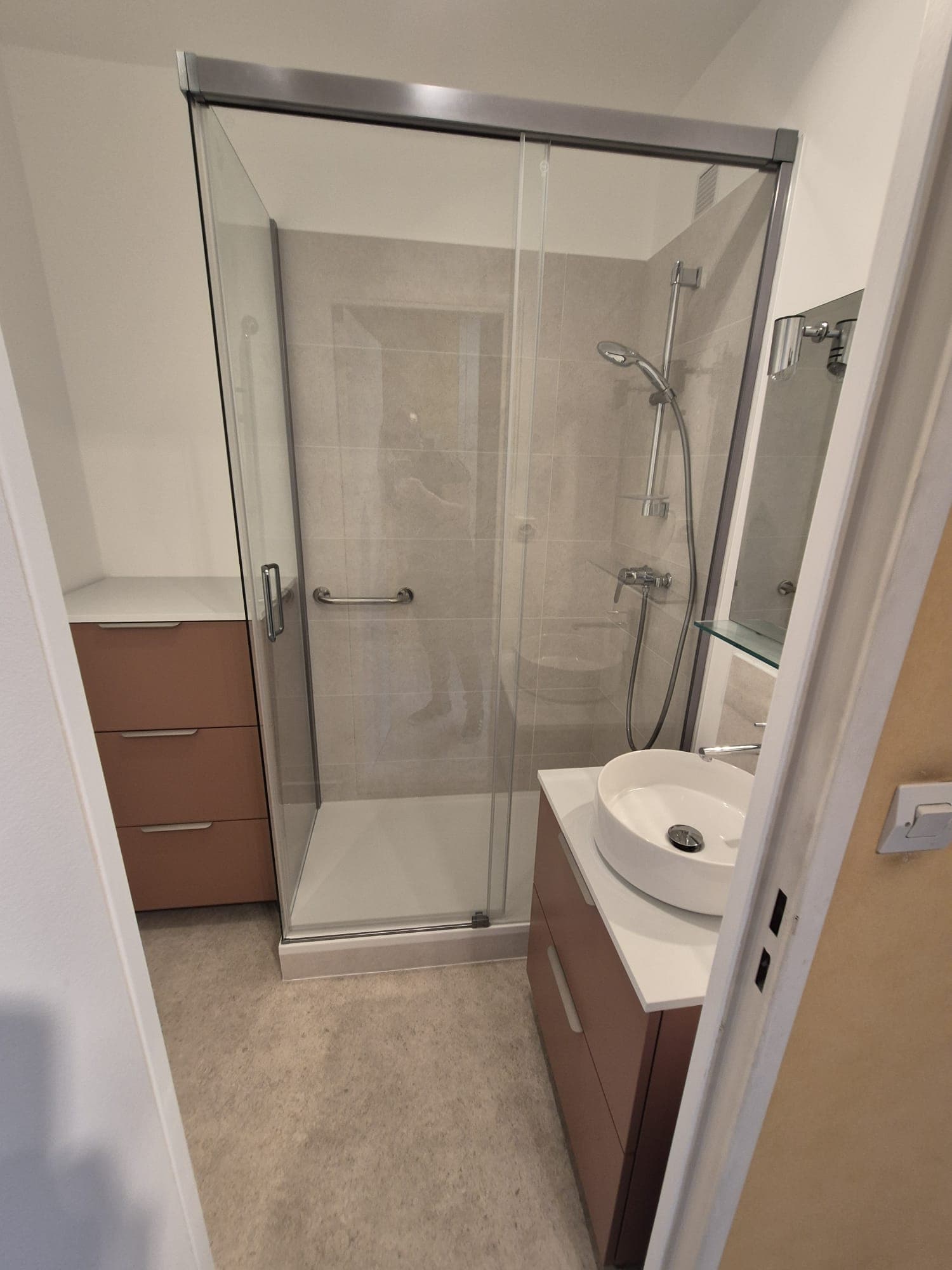 Salle de bain terminée : douche à paroi vitrée, meuble vasque bois et vasque ronde