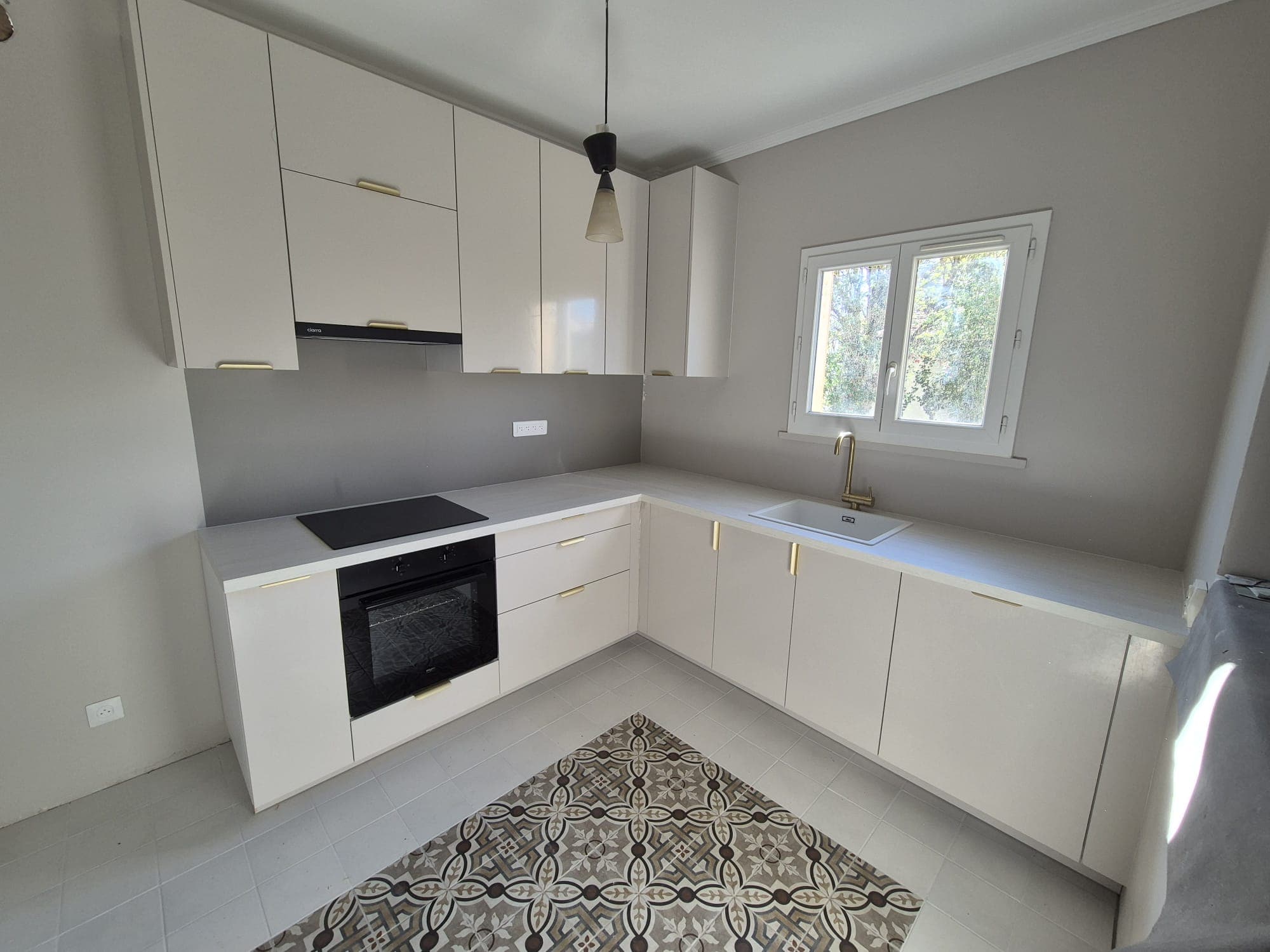 Cuisine blanche avec suspension noire et tapis de carreaux de ciment